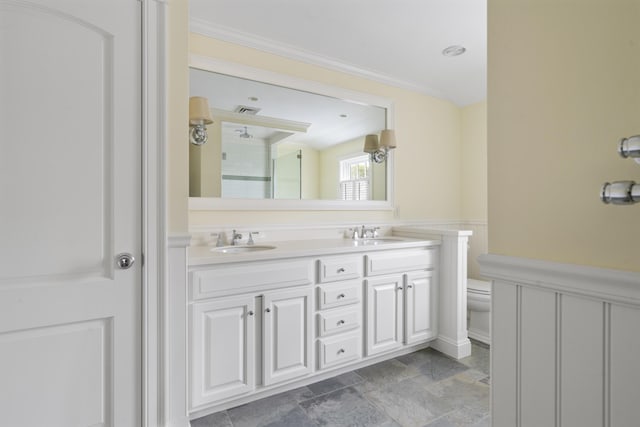 52 Lester B Orcutt Blvd, Biddeford, ME 04006 - bathroom featuring double vanity, toilet, crown molding, a shower, and a wainscoted wall