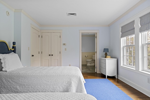 52 Lester B Orcutt Blvd, Biddeford, ME 04006 - bedroom featuring crown molding, dark wood-style floors, baseboards, ensuite bath, and wainscoting