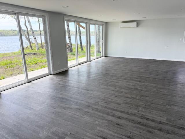 5 N Vigue Shore Rd, Albion, ME 04910 - unfurnished room with a wall mounted AC, a water view, and baseboards