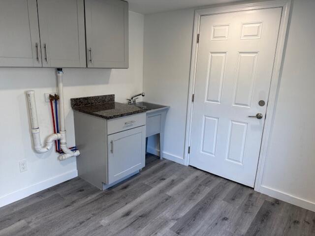 5 N Vigue Shore Rd, Albion, ME 04910 - kitchen with baseboards, wood finished floors, gray cabinets, and dark stone countertops