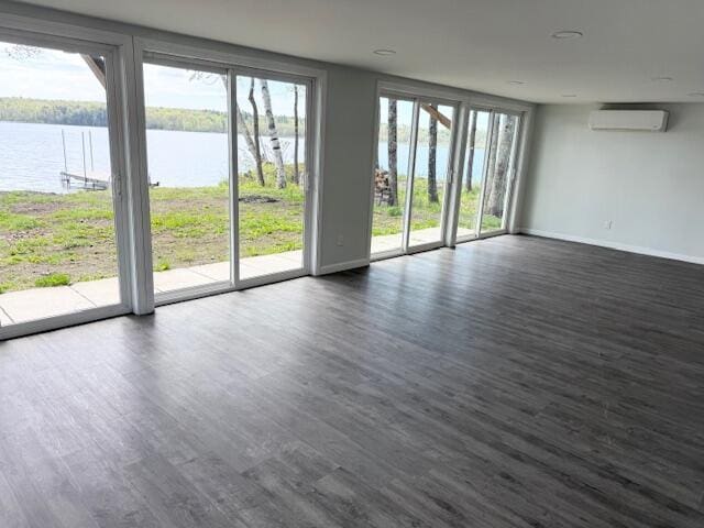 5 N Vigue Shore Rd, Albion, ME 04910 - unfurnished room with a water view, an AC wall unit, dark wood-type flooring, and baseboards