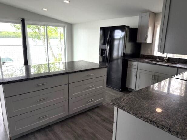 5 N Vigue Shore Rd, Albion, ME 04910 - kitchen featuring black fridge with ice dispenser, dark wood finished floors, dark stone countertops, recessed lighting, and a sink