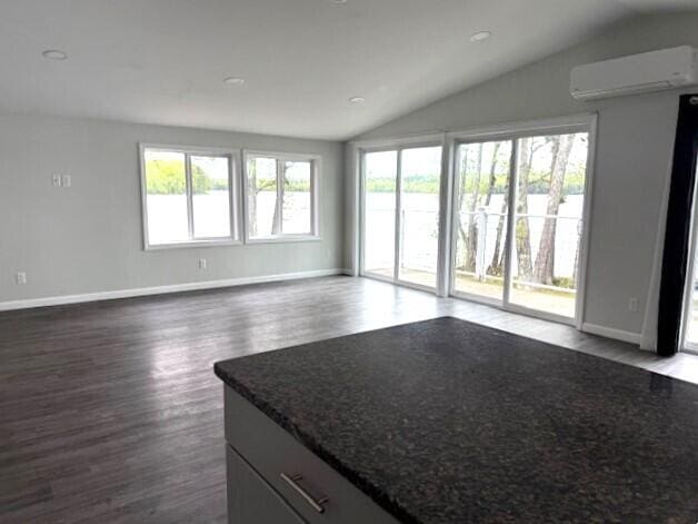5 N Vigue Shore Rd, Albion, ME 04910 - unfurnished room featuring a wall mounted air conditioner, vaulted ceiling, healthy amount of natural light, and dark wood-type flooring