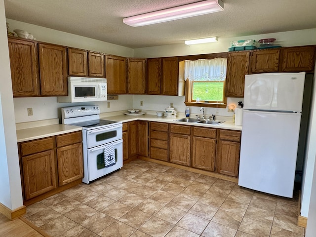 2 Cemetery Rd, Eastport, ME 04631 - kitchen featuring white appliances, a sink, brown cabinets, and a textured ceiling