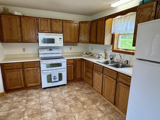 2 Cemetery Rd, Eastport, ME 04631 - kitchen featuring white appliances, a sink, brown cabinetry, and a textured ceiling
