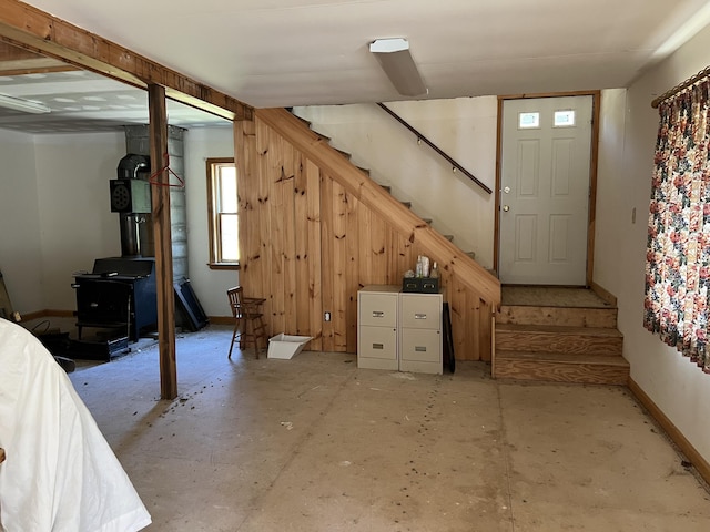 640 Bald Mountain Rd, Rangeley, ME 04970 - below grade area with stairway, a wood stove, and baseboards