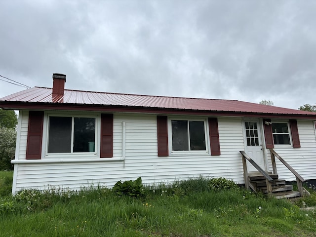 1407 Stage Rd, Etna, ME 04434 - back of house featuring entry steps, a metal roof, and a chimney