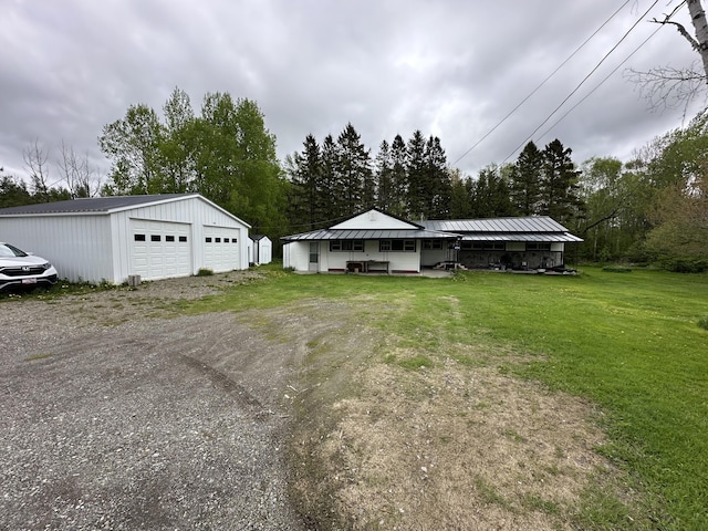 694 Calais Rd, Hodgdon, ME 04730 - view of front of property with a detached garage, an outdoor structure, and a front lawn