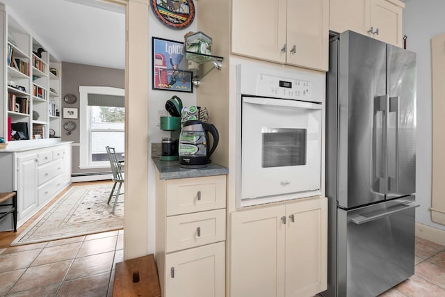 116 Whipple Rd, Kittery, ME 03904 - kitchen featuring freestanding refrigerator, oven, open shelves, light tile patterned flooring, and a baseboard heating unit
