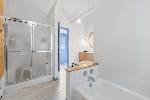 14 Lakeshore Dr, Belgrade, ME 04918 - bathroom featuring vanity, a stall shower, a garden tub, wood finished floors, and vaulted ceiling
