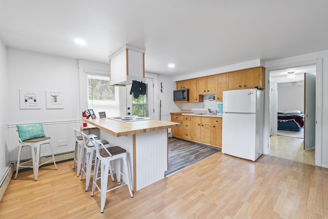 14 Lakeshore Dr, Belgrade, ME 04918 - kitchen with freestanding refrigerator, light wood finished floors, a breakfast bar area, recessed lighting, and a peninsula