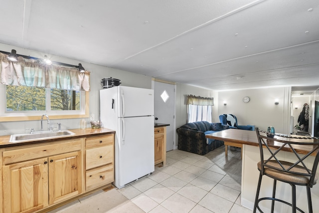 14 Lakeshore Dr, Belgrade, ME 04918 - kitchen featuring a sink, freestanding refrigerator, open floor plan, light tile patterned floors, and light brown cabinetry
