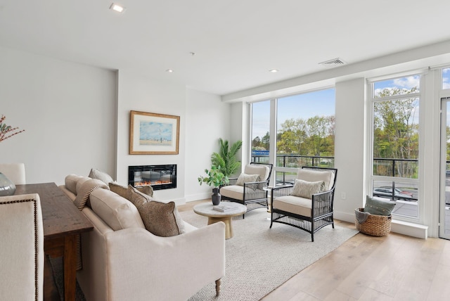267 US Route 1 Unit 206, Falmouth, ME 04105 - living room featuring a glass covered fireplace, wood finished floors, baseboards, and recessed lighting