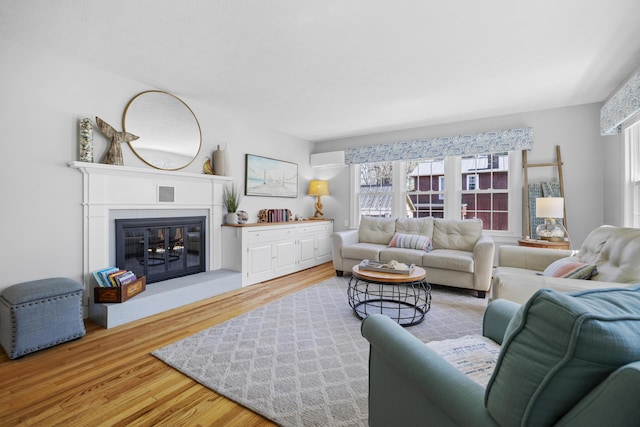 10 Lake Ave, Old Orchard Beach, ME 04064 - living room with light wood-style floors, a glass covered fireplace, and a wall unit AC