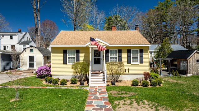 10 Lake Ave, Old Orchard Beach, ME 04064 - bungalow-style home with a chimney, a front yard, an outbuilding, and a shingled roof