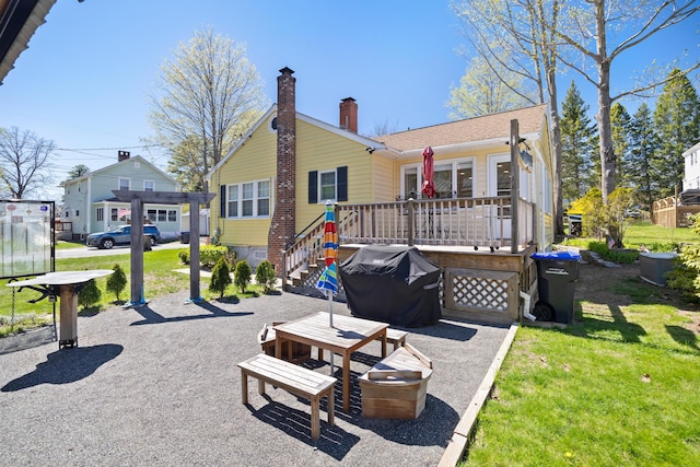 10 Lake Ave, Old Orchard Beach, ME 04064 - rear view of house with a wooden deck, an attached garage, a lawn, and a chimney