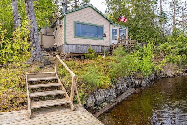 18 Breezy Knoll Dr, Princeton, ME 04668 - back of property with stairs, a deck with water view, and an AC wall unit