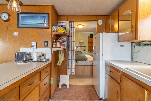 18 Breezy Knoll Dr, Princeton, ME 04668 - kitchen featuring brown cabinetry, light countertops, freestanding refrigerator, wooden ceiling, and carpet