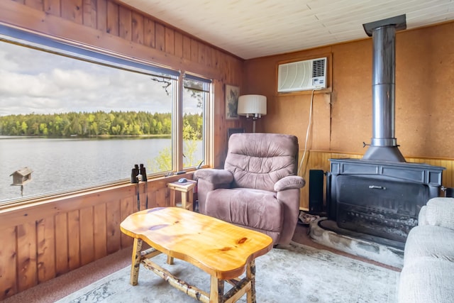 18 Breezy Knoll Dr, Princeton, ME 04668 - living area featuring wooden walls, a wall mounted AC, a wood stove, a water view, and carpet floors