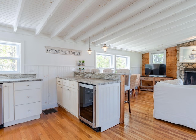 11 Saccarappa Ln, Scarborough, ME 04074 - kitchen featuring wine cooler, a breakfast bar, white cabinetry, light wood-style flooring, and a wainscoted wall