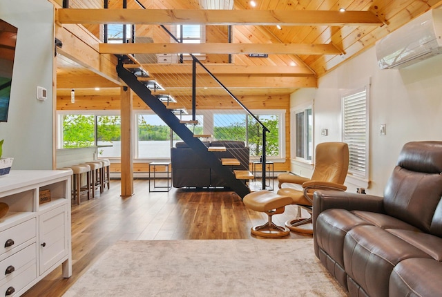 7 Scenic View Dr, Naples, ME 04055 - living room with wood ceiling with exposed beams, a wall mounted AC, wood finished floors, stairs, and wood walls