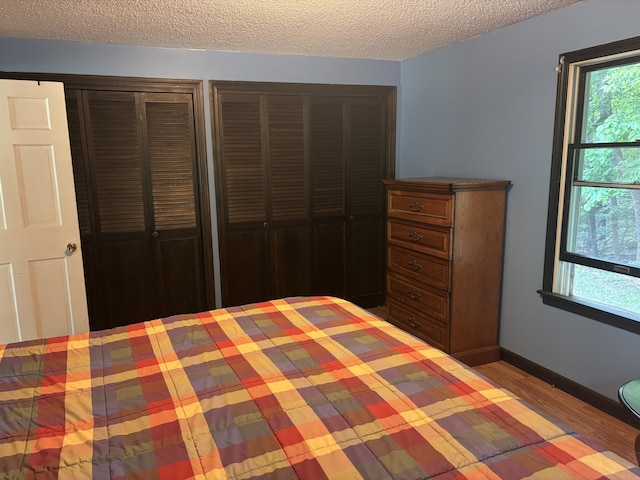 270 Mccrillis Corner Rd, Wilton, ME 04294 - unfurnished bedroom featuring a textured ceiling, multiple closets, and wood finished floors