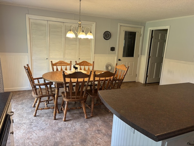 270 Mccrillis Corner Rd, Wilton, ME 04294 - dining room with a wainscoted wall, crown molding, a textured ceiling, and a chandelier