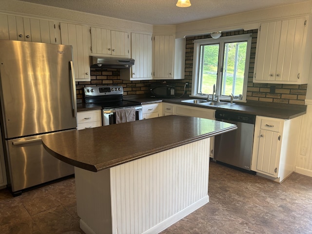270 Mccrillis Corner Rd, Wilton, ME 04294 - kitchen with stainless steel appliances, dark countertops, under cabinet range hood, backsplash, and a textured ceiling
