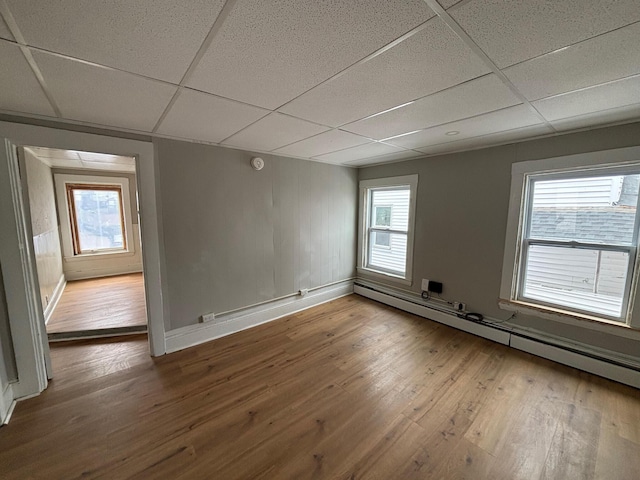 39 Foss St, Biddeford, ME 04005 - spare room featuring a baseboard radiator, hardwood / wood-style floors, a paneled ceiling, baseboards, and healthy amount of natural light