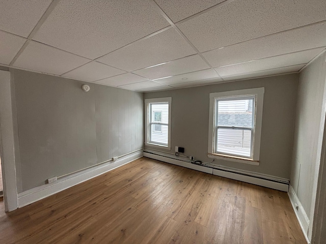 39 Foss St, Biddeford, ME 04005 - empty room featuring a baseboard heating unit, hardwood / wood-style floors, a paneled ceiling, and baseboards