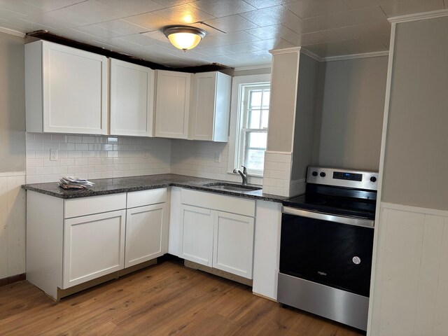 39 Foss St, Biddeford, ME 04005 - kitchen featuring stainless steel range with electric cooktop, a sink, ornamental molding, dark wood-style flooring, and white cabinets