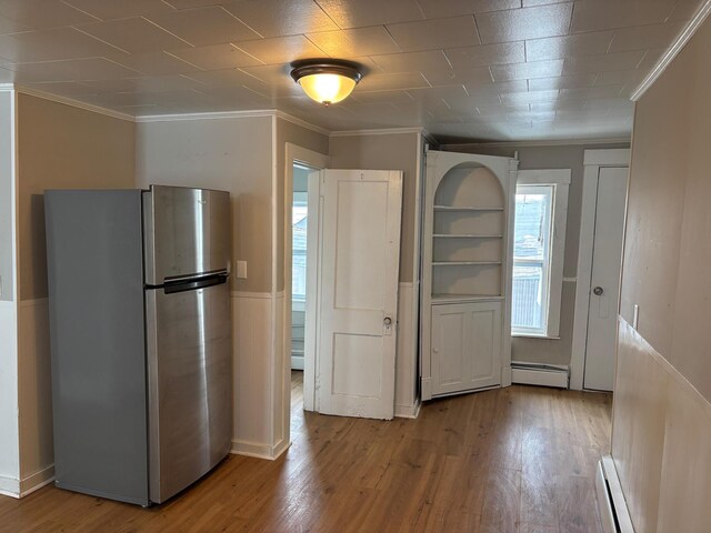 39 Foss St, Biddeford, ME 04005 - kitchen with freestanding refrigerator, baseboard heating, crown molding, wood finished floors, and a wainscoted wall