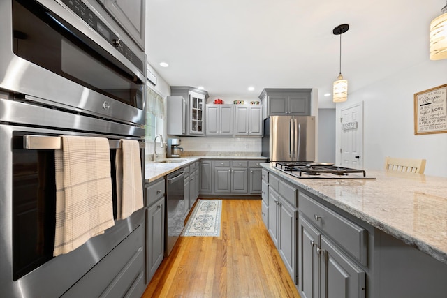 30 Maxfield Dr, Orono, ME 04473 - kitchen with gray cabinetry, appliances with stainless steel finishes, a sink, glass insert cabinets, and light wood finished floors
