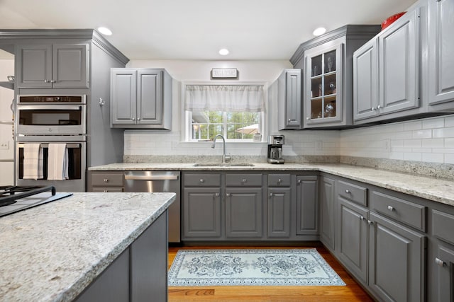 30 Maxfield Dr, Orono, ME 04473 - kitchen with gray cabinets, a sink, stainless steel appliances, glass insert cabinets, and decorative backsplash