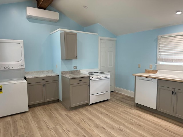 70 Pearl St, Bangor, ME 04401 - kitchen with white appliances, gray cabinetry, vaulted ceiling, stacked washer / drying machine, and a wall mounted AC