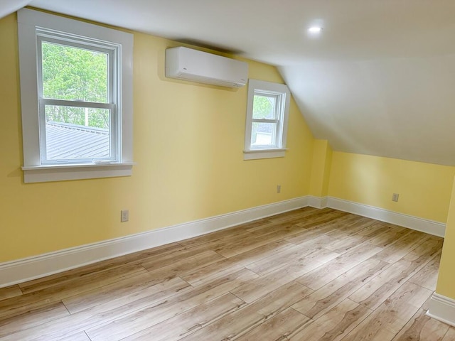 70 Pearl St, Bangor, ME 04401 - additional living space featuring an AC wall unit, light wood-style flooring, vaulted ceiling, and baseboards