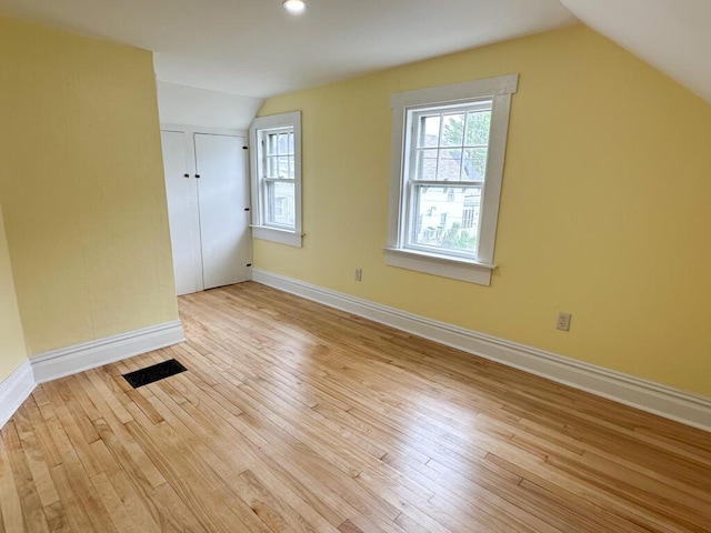 70 Pearl St, Bangor, ME 04401 - unfurnished bedroom with vaulted ceiling, light wood finished floors, baseboards, multiple windows, and a closet