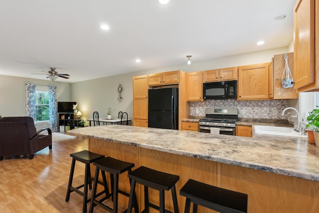 32 Edgefield Ln Unit 5, Brunswick, ME 04011 - kitchen featuring black appliances, a sink, a peninsula, decorative backsplash, and ceiling fan