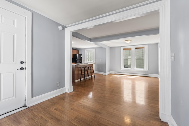 130 W Broadway, Bangor, ME 04401 - unfurnished living room with a baseboard heating unit and wood finished floors