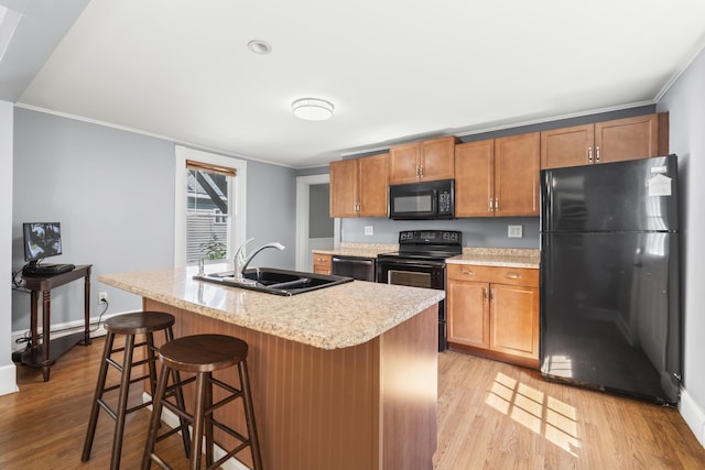 130 W Broadway, Bangor, ME 04401 - kitchen featuring black appliances, a baseboard heating unit, light wood-style floors, crown molding, and light countertops
