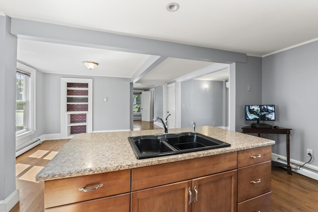130 W Broadway, Bangor, ME 04401 - kitchen featuring baseboard heating, dark wood finished floors, a center island with sink, and light stone countertops