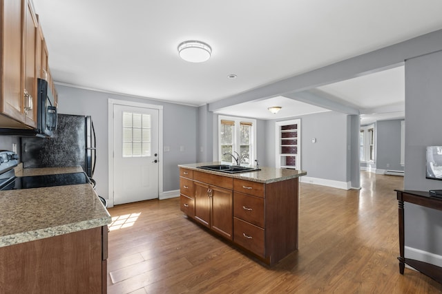 130 W Broadway, Bangor, ME 04401 - kitchen featuring wood finished floors, a center island, black microwave, and baseboard heating