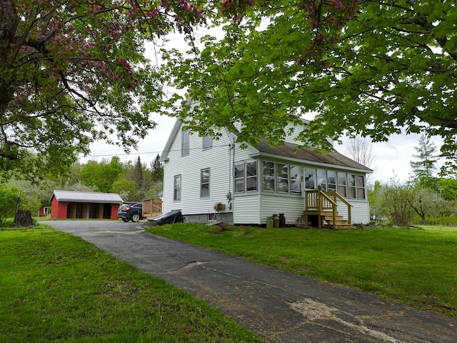 90 W Main St, Milo, ME 04463 - view of front of house with a front yard, a shingled roof, and a sunroom