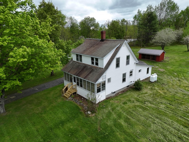 90 W Main St, Milo, ME 04463 - rear view of property featuring a sunroom, a chimney, a shingled roof, and a yard