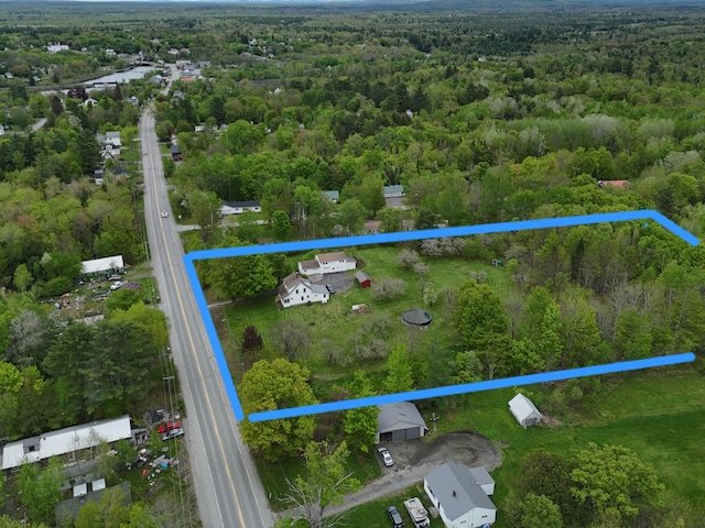 90 W Main St, Milo, ME 04463 - aerial overview of property's location with property parcel outlined and a heavily wooded area
