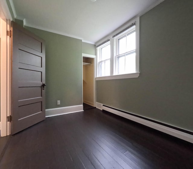90 W Main St, Milo, ME 04463 - unfurnished bedroom featuring baseboard heating, dark wood-style flooring, baseboards, a closet, and crown molding