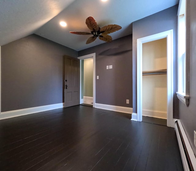 90 W Main St, Milo, ME 04463 - unfurnished bedroom featuring a baseboard radiator, dark wood-style floors, baseboards, vaulted ceiling, and a closet