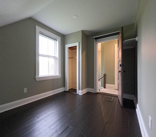 90 W Main St, Milo, ME 04463 - unfurnished bedroom with dark wood finished floors, vaulted ceiling, and baseboards