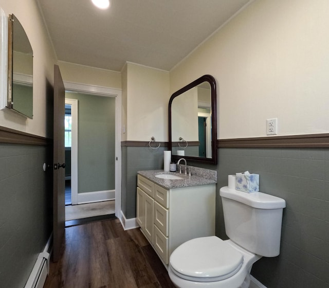 90 W Main St, Milo, ME 04463 - bathroom with tile walls, toilet, baseboard heating, vanity, and wood finished floors