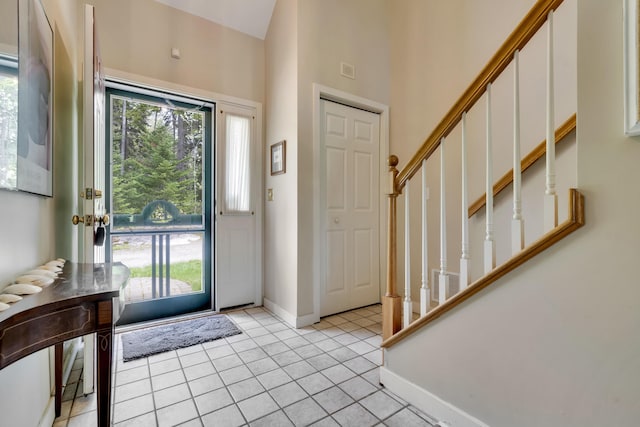 2 Round Cove Ln Unit 2, Phippsburg, ME 04562 - foyer entrance featuring stairs, light tile patterned flooring, a towering ceiling, and baseboards